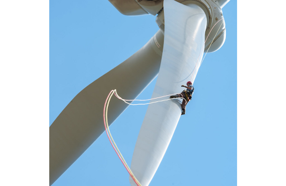 An operator climbing a wind turbine for inspection/maintenance