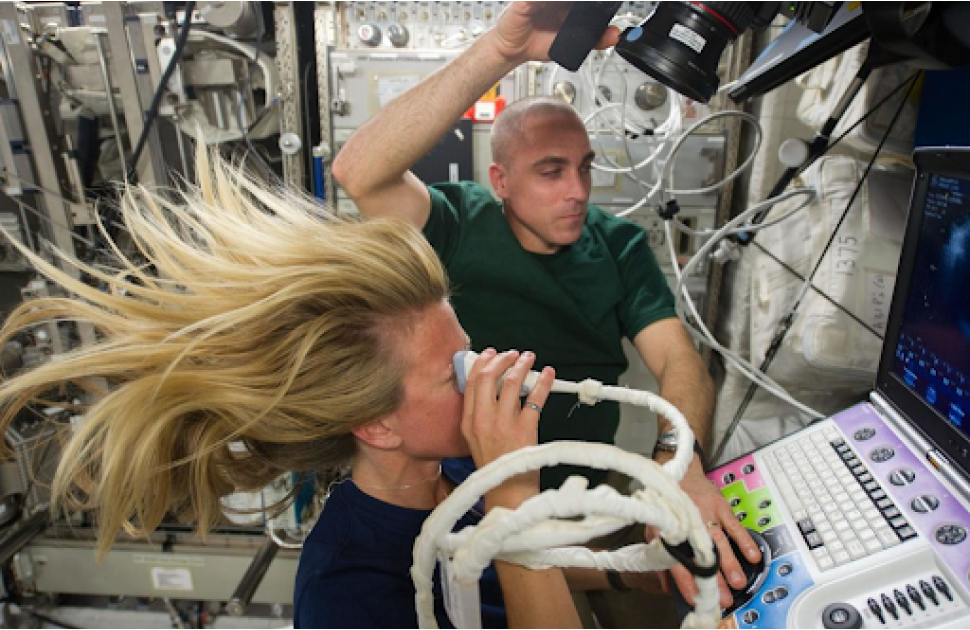 Astronaut Karen Nyberg, Expedition 37 flight engineer, assisted by astronaut Chris Cassidy, performs an Ocular Health (OH) Ultrasound 2 scan in the Destiny laboratory of the International Space Station