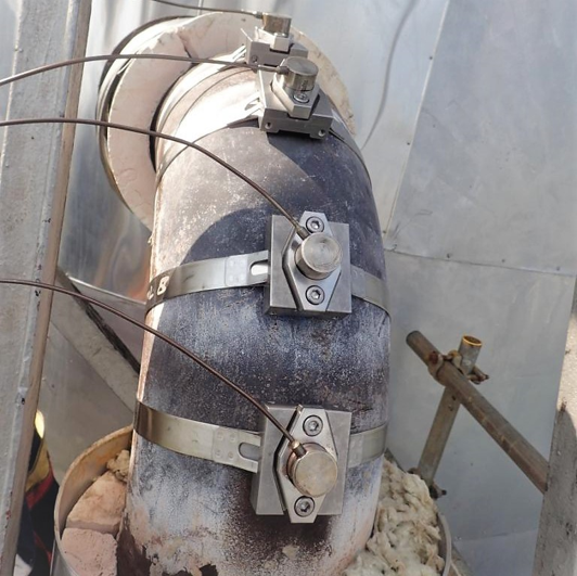 Fixed ultrasonic transducers installed on high-temperature pipeline for real-time sulfidation corrosion wall thickness monitoring Permanent ultrasonic sensors mounted on insulated refinery pipeline for continuous on-stream corrosion monitoring